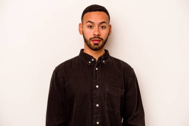 Genç İspanyol adam beyaz arka planda izole edilmiş üzgün, ciddi yüzlü, mutsuz ve hoşnutsuz..