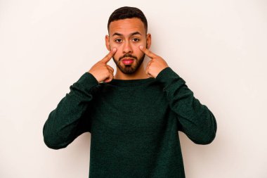 Beyaz arka planda izole edilmiş genç İspanyol bir adam ağlıyor, bir şeyden memnun değil, acı ve kafa karışıklığı konsepti..