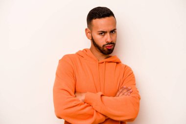 Beyaz arka planda izole edilmiş genç İspanyol adam alaycı bir ifadeyle kameraya bakıyor..