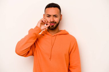 Beyaz arka planda izole edilmiş genç İspanyol adam parmakları dudaklarında bir sır saklıyor..
