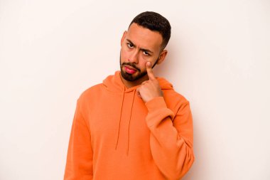 Beyaz arka planda izole edilmiş genç İspanyol bir adam ağlıyor, bir şeyden memnun değil, acı ve kafa karışıklığı konsepti..