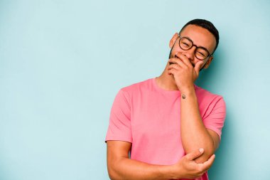 Genç İspanyol adam mavi arka planda izole edilmiş gülerek, kaygısızca, doğal duygularla.