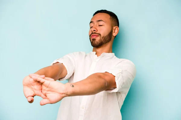 Young Hispanic Man Isolated Blue Background Stretching Arms Relaxed Position — 스톡 사진