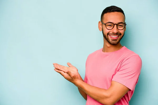 Joven Hispano Aislado Sobre Fondo Azul Sosteniendo Espacio Copia Una — Foto de Stock