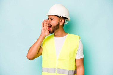 Genç ispanyol işçi mavi arka planda izole edilmiş bağırıyor ve avuç içini açık tutuyordu..