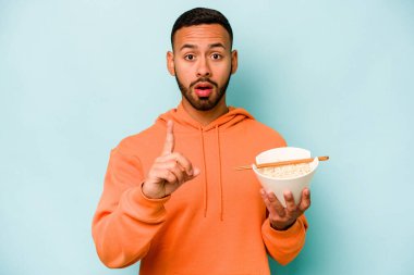 Mavi arka planda izole edilmiş erişte yiyen genç İspanyol kadının bir fikri var, ilham verici bir kavram..