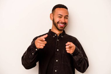 Beyaz arka planda izole edilmiş genç İspanyol adam parmaklarıyla ön tarafı işaret ediyor..