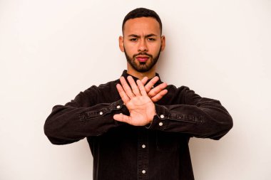 Beyaz arka planda izole edilmiş genç İspanyol adam elini uzatmış, dur işareti göstererek seni engelliyor..