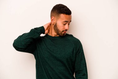 Beyaz arka planda izole edilmiş genç İspanyol bir adam stresten dolayı boynu ağrıyor, masaj yapıyor ve elle dokunuyor..