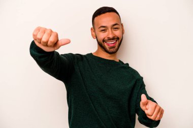 Beyaz arka planda izole edilmiş genç bir İspanyol. Baş parmağını kaldırıyor, gülümsüyor ve kendinden emin..