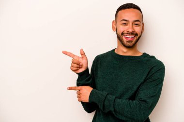 Beyaz arka planda izole edilmiş genç bir İspanyol işaret parmaklarıyla işaret ederek heyecanlanıyor..