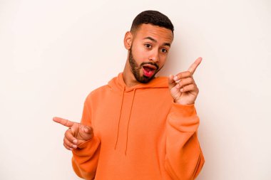 Beyaz arka planda izole edilmiş genç İspanyol adam farklı kopya alanlarını gösteriyor, birini seçiyor, parmaklarıyla gösteriyor..
