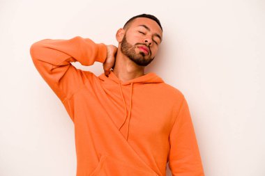 Genç İspanyol bir adam beyaz arka planda izole edilmiş, dirsek masajı yapıyor, kötü bir hareketin ardından acı çekiyor..