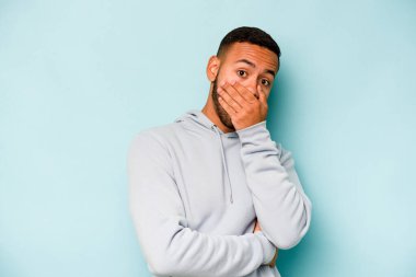 Genç İspanyol adam mavi arka planda izole edilmiş korkmuş ve korkmuş..