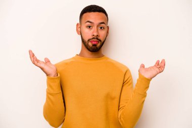 Beyaz arka planda izole edilmiş genç bir İspanyol şüpheli ve sorgulama sırasında omuz silkiyor..