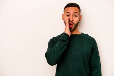 Beyaz arka planda izole edilmiş genç İspanyol bir adam gizli bir sıcak fren haberi veriyor ve yana bakıyor.