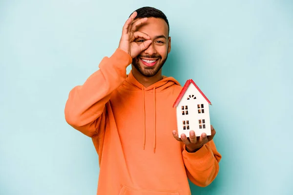 Young Hispanic Man Holding Toy House Isolated Blue Background Excited — Stock Photo, Image