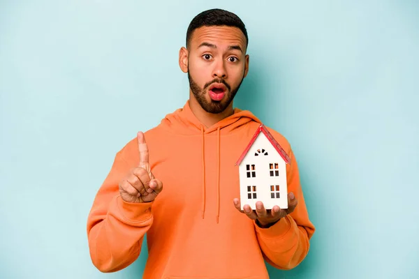 Young Hispanic Man Holding Toy House Isolated Blue Background Having — Stock Photo, Image