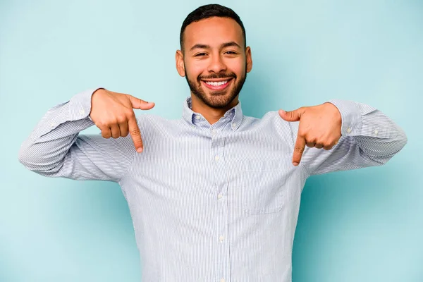 Joven Hombre Hispano Aislado Sobre Fondo Azul Apunta Hacia Abajo — Foto de Stock