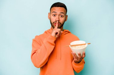 Mavi arka planda izole edilmiş erişte yiyen genç İspanyol kadın ya sır saklıyor ya da sessizlik istiyor..