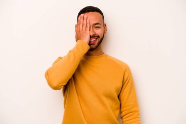 Beyaz arka planda izole edilmiş, yüzünün yarısını palmiye ile örterek eğlenen genç bir İspanyol..