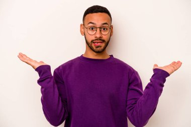 Beyaz arka planda izole edilmiş genç İspanyol bir adam. Kafası karışmış ve omuz silkiyor. Kopya alanını tutmak için..