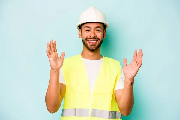 Young Laborer Hispanic Man Isolated Blue Background Receiving Pleasant Surprise — Stock Photo, Image