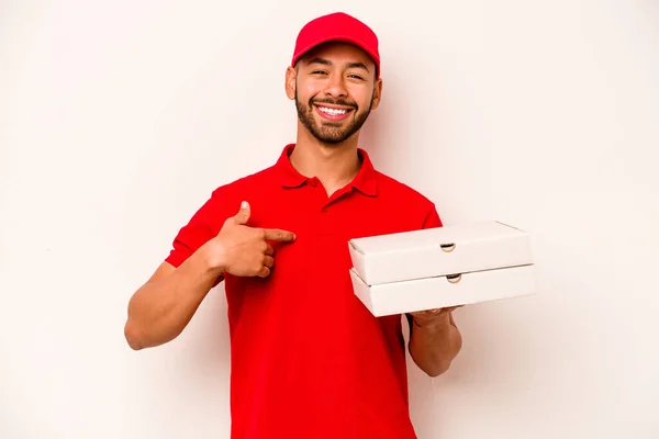 若いですヒスパニック系の配達人を保持しているピザ隔離された上に白い背景人指摘によって手にシャツコピースペース 誇りと自信 — ストック写真