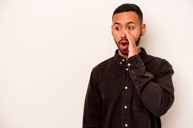 Beyaz arka planda izole edilmiş genç İspanyol adam gördüğü bir şey yüzünden şoka uğruyor..