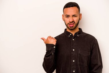 Beyaz arka planda izole edilmiş genç İspanyol adam işaret parmağıyla fotokopi alanını işaret ederek şok oldu..