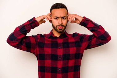 Beyaz arka planda izole edilmiş genç İspanyol bir adam bir göreve odaklanmış, işaret parmaklarını işaret ediyor..