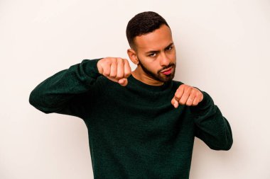 Latin kökenli genç bir adam beyaz arka planda izole edilmiş. Yumruk atıyor, sinirleniyor, kavga ediyor..