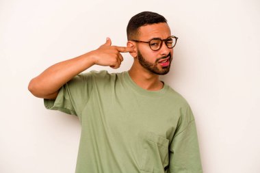 Beyaz arka planda izole edilmiş genç İspanyol adam kulaklarını elleriyle kapatıyor..