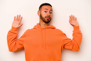 Beyaz arka planda izole edilmiş genç bir İspanyol, yakın bir tehlike nedeniyle şok oluyor.