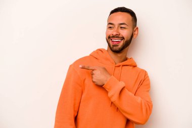 Beyaz arka planda soyutlanmış genç İspanyol adam gülümseyen, neşeli ve keyifli bir kenara bakıyor..