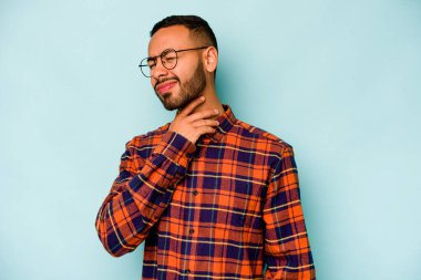 Mavi arka planda izole edilmiş genç İspanyol bir adam virüs ya da enfeksiyon yüzünden boğazında ağrı hissediyor..