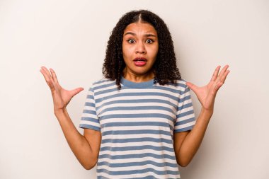 Beyaz arka planda izole edilmiş genç Afrikalı Amerikalı kadın gökyüzüne haykırıyor, bakıyor, hayal kırıklığına uğruyor..