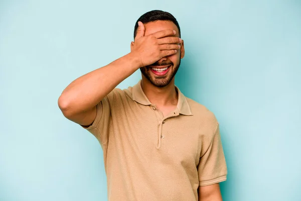 Young Hispanic Man Isolated Blue Background Covers Eyes Hands Smiles — стоковое фото