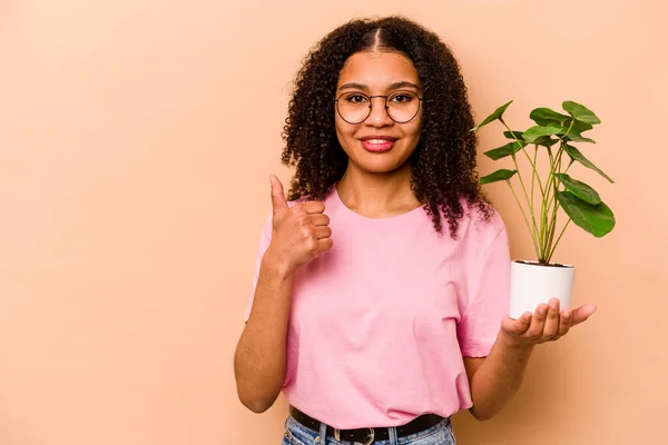 Young African American Woman Holding Plant Isolated Beige Background Smiling — 스톡 사진