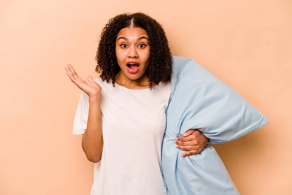 Young African American Woman Holding Pillow Isolated Beige Background Surprised — Foto Stock