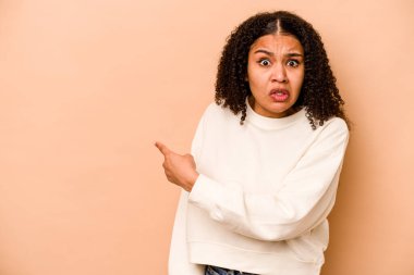 Genç Afrikalı Amerikalı kadın bej arka planda izole edilmiş.