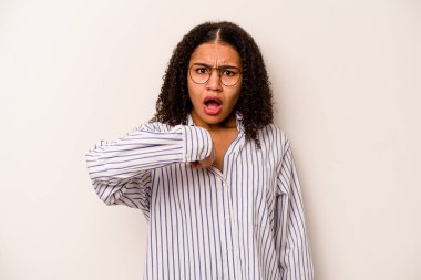 Beyaz arka planda izole edilmiş genç Afrikalı Amerikalı kadın parmağını göstererek şaşırdı ve gülümsedi..