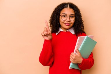 Genç Afro-Amerikan kadın öğrenci. Bej arka planda izole edilmiş. Parmak izi 1 numara..