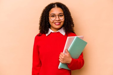 Genç Afrikalı Amerikalı kadın izole edilmiş bej arka planda mutlu, gülümseyen ve neşeli.