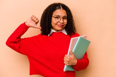 Bej arka planda izole edilmiş genç Afrikalı Amerikalı kadın gururlu ve kendinden emin hissediyor, örnek olarak..