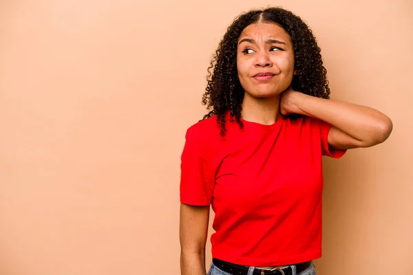 Joven Mujer Afroamericana Aislada Sobre Fondo Beige Tocando Parte Posterior —  Fotos de Stock