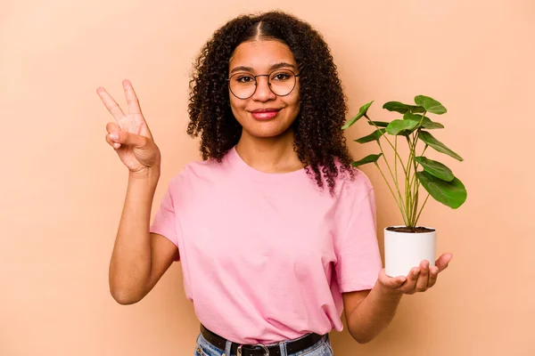 아름답고 배경에서 고립된 식물을 아프리카계 소녀는 손가락으로 평화의 상징을 자랑스럽고 — 스톡 사진