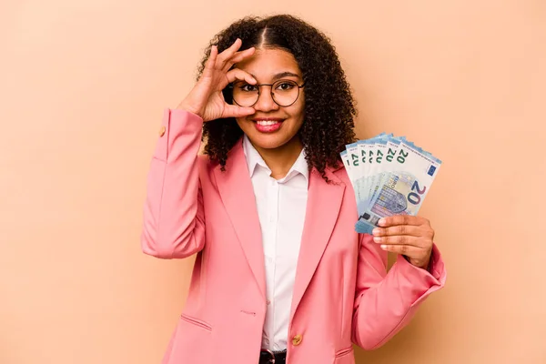 若いアフリカ系アメリカ人のビジネス女性は ベージュの背景に隔離された紙幣を保持興奮しました — ストック写真