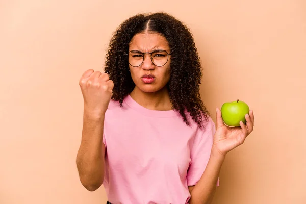 Ung Afroamerikansk Kvinna Som Håller Ett Äpple Isolerat Beige Bakgrund — Stockfoto