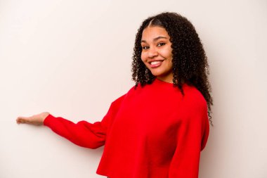 Beyaz arka planda izole edilmiş genç Afrikalı Amerikalı kadın hoş bir ifade sergiliyor..